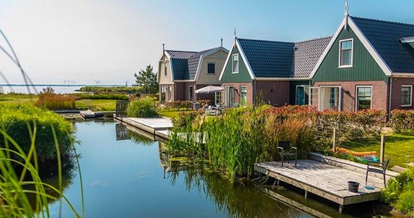 Luxe vakantiehuis met rieten dak aan het water bij EuroParcs Poort van Amsterdam, geschikt voor 6 personen.