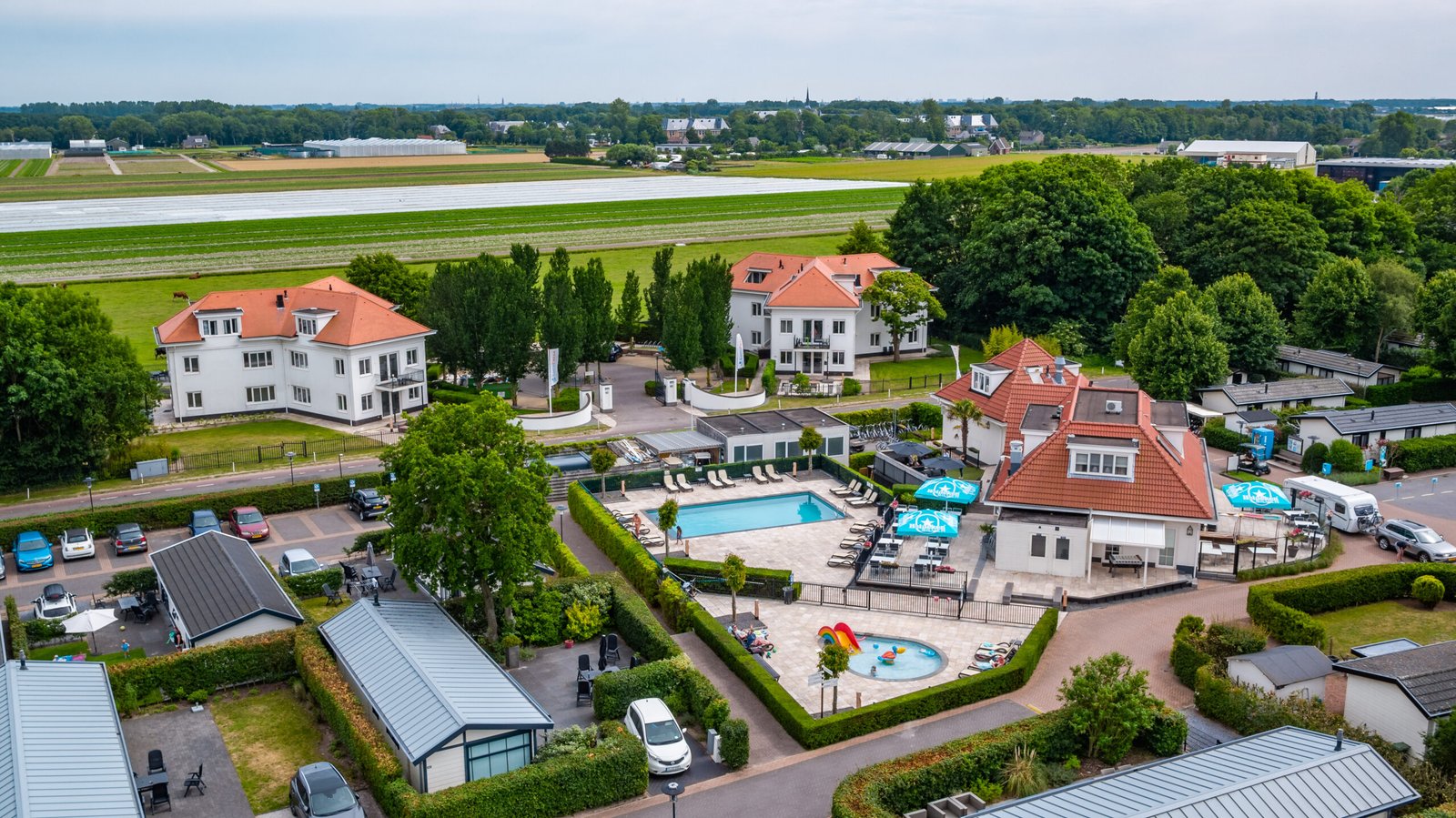 Afbeelding bij EuroParcs Noordwijkse Duinen Luchtfoto van EuroParcs Noordwijkse Duinen, met luxe vakantiehuisjes tussen de duinen en groen, vlakbij de kust.