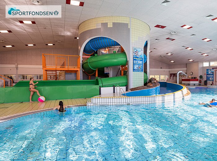 Familie geniet van vrijzwemmen in het Sportfondsen Rivièrabad in Spijkenisse, met glijbanen en waterplezier.