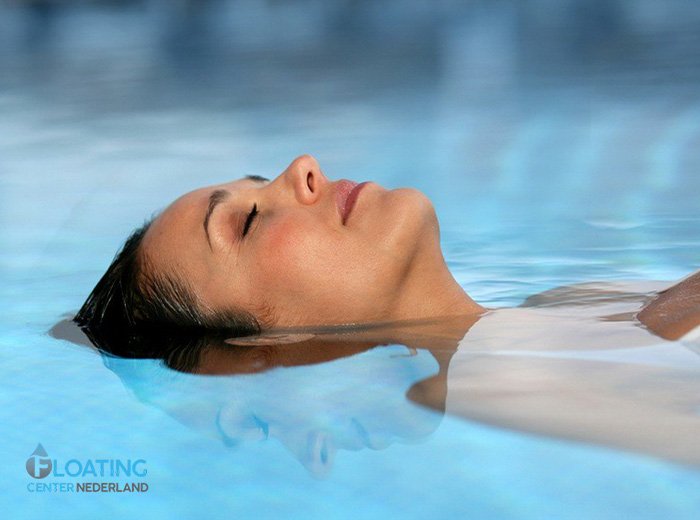 Een persoon ligt ontspannen in een float tank bij Floating Center Nederland in Amersfoort, met gedimd licht en rustgevende sfeer.