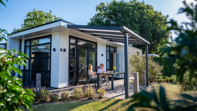 Vakantiegasten ontspannen op het terras van hun luxe woning bij Résidence de Leuvert in Cromvoirt, omringd door groen.